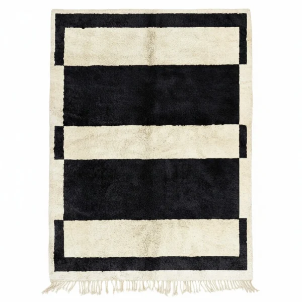 Handwoven wool rug with bold black and cream horizontal stripes and fringe, modern Moroccan design.