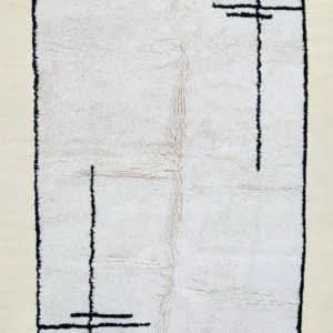 A minimalist Beni Ourain rug featuring simple black geometric lines on a soft, cream-colored wool background, with fringes on the edges